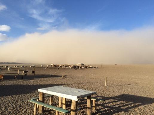 A dust storm approaches a lonely picnic table