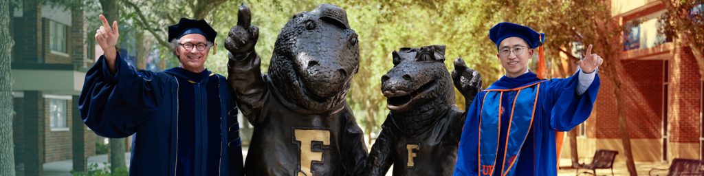 Professor Mark Orazem and new graduate Dr. Chen You posing with statues of UF mascots Albert and Alberta